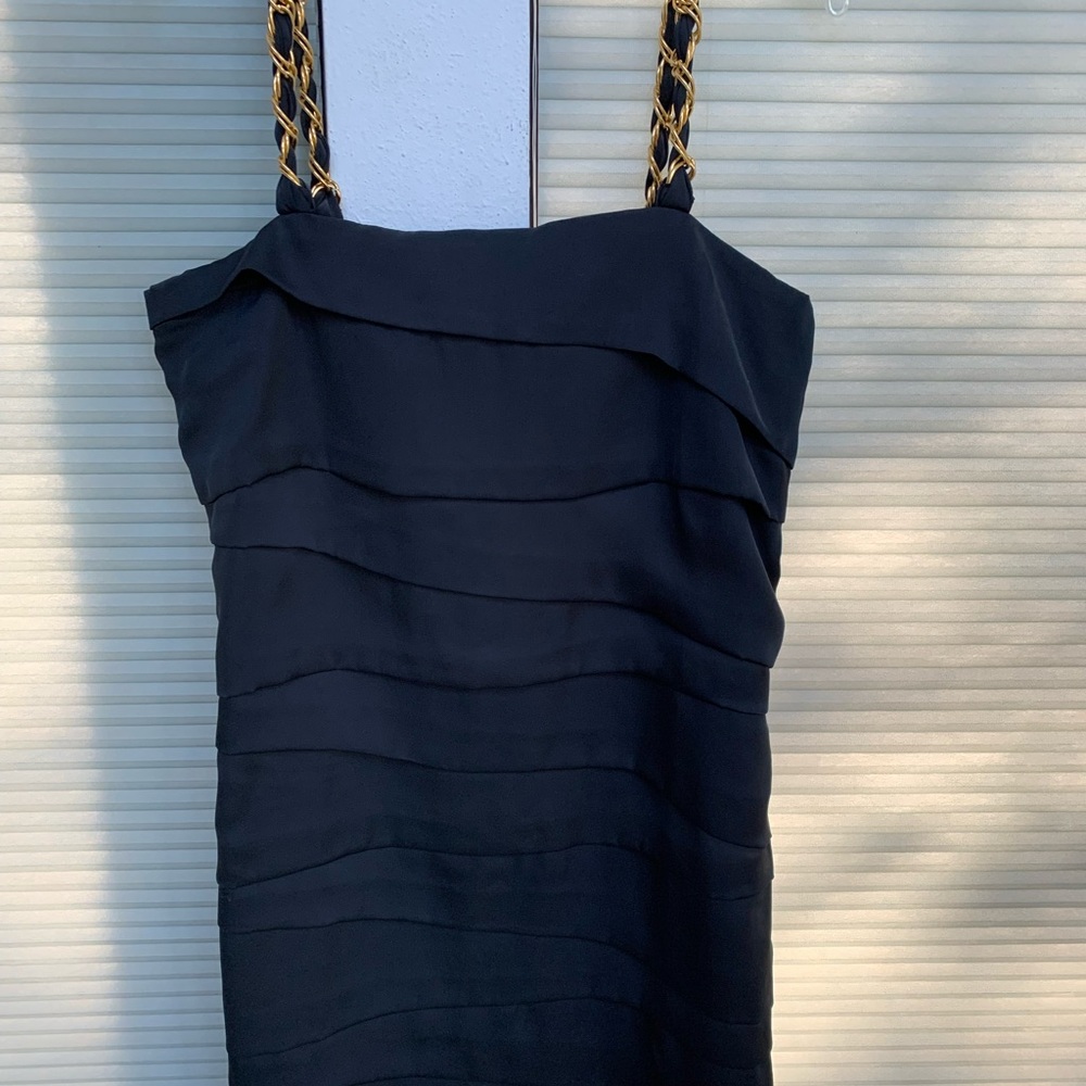 Black short dress. Gold straps.